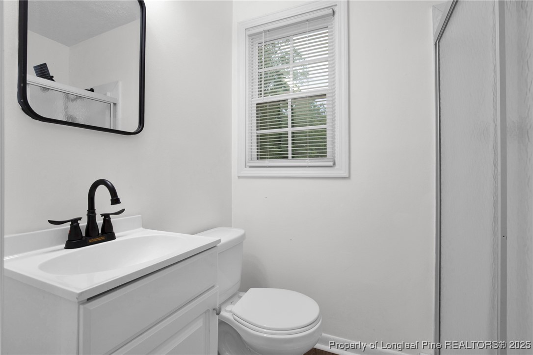 309 Cornith Road Pembroke, NC 28372 - Photo 30 of 40 a bathroom with a toilet a sink and mirror