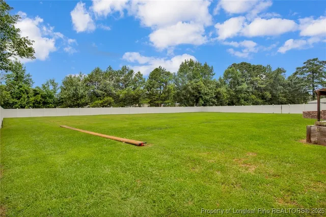 a view of a big yard with a house in the background