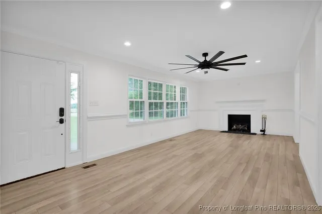 a view of an empty room with a fireplace and a window