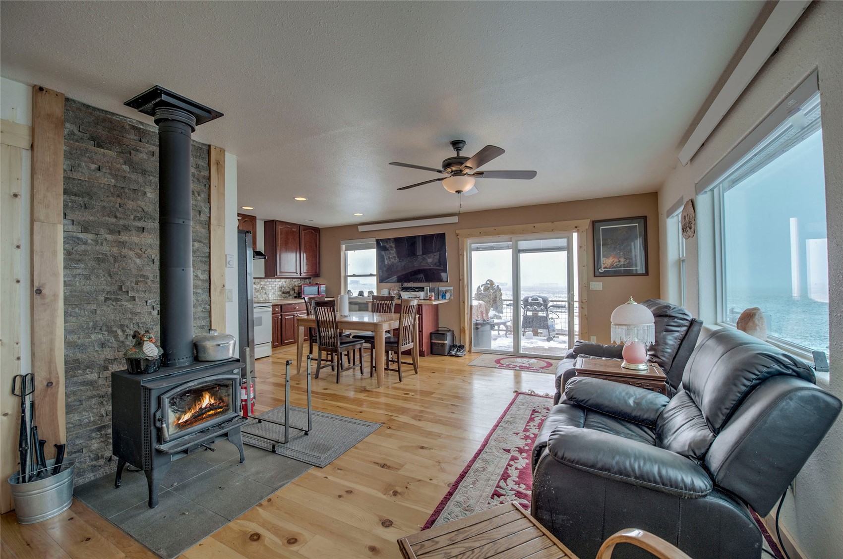1620 Trout Road Fairplay, CO 80440 - Photo 8 of 31 Living room with a wood stove, ceiling fan, and light wood-type flooring