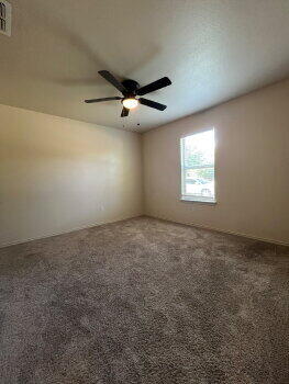 3205 112th Street Lubbock, TX 79423 - Photo 14 of 19 en empty room with windows and ceiling fan view