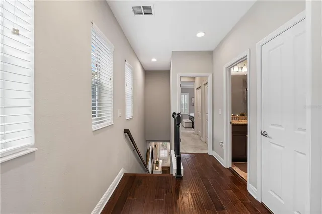 a view of a hallway with wooden floor and stairs