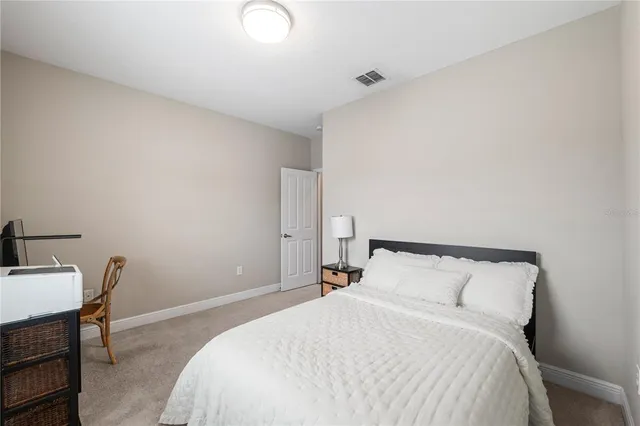 a bedroom with a bed a table and chair