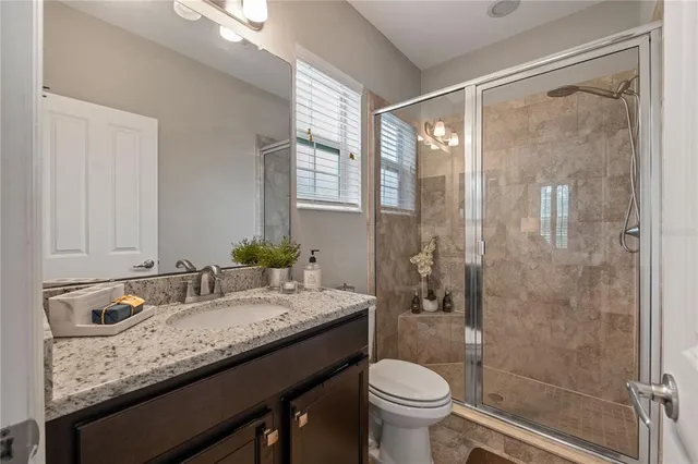 a bathroom with a granite countertop sink toilet and shower