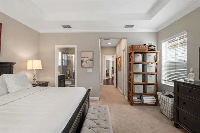 a spacious bedroom with a bed a dresser and book shelf