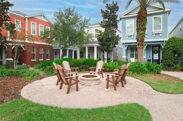 a view of a patio with table and chairs potted plants and floor to ceiling window
