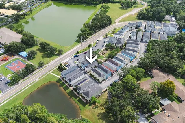 an aerial view of residential houses with outdoor space and lake view