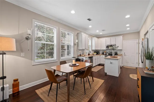 a kitchen with a dining table chairs and refrigerator