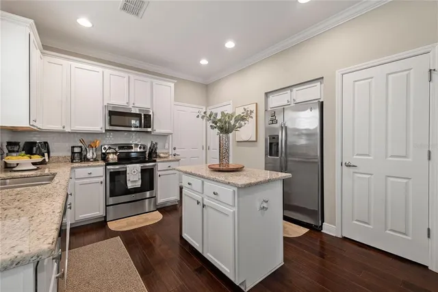 a kitchen with white cabinets and stainless steel appliances