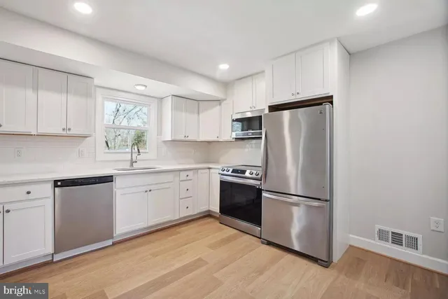a kitchen with wooden cabinets and stainless steel appliances