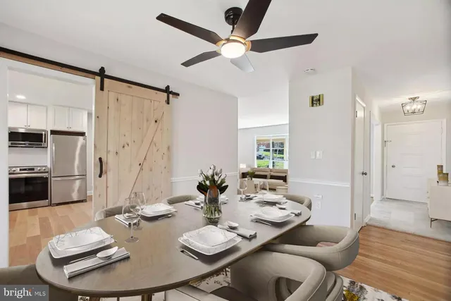 a view of a dining room with furniture a rug and wooden floor