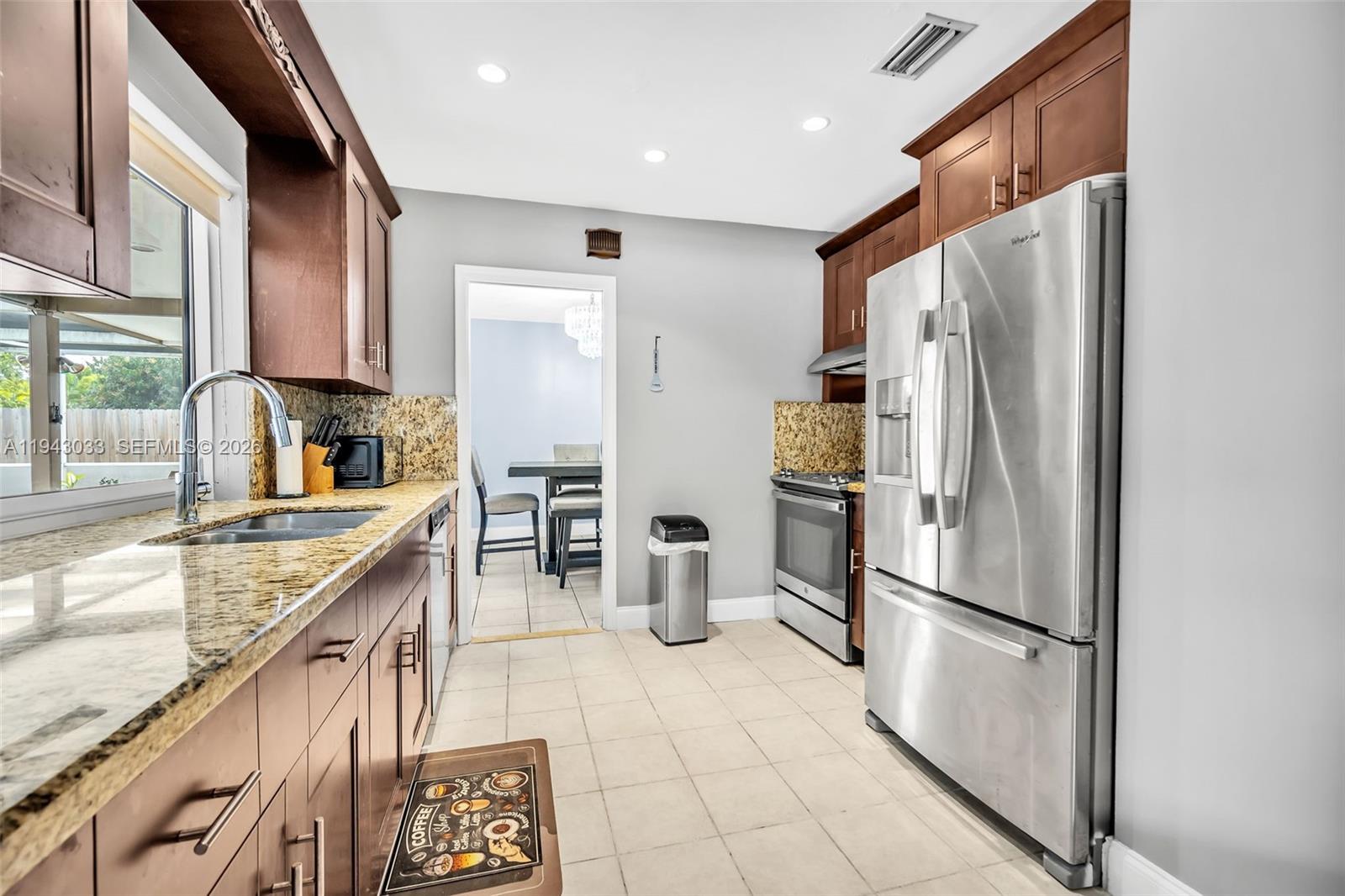 2211 North 50th Avenue Hollywood, FL 33021 - Photo 10 of 45 a kitchen with stainless steel appliances granite countertop a refrigerator and a sink