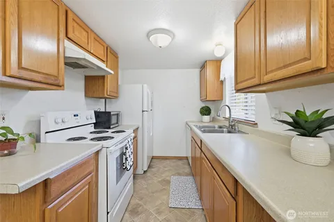 a kitchen with stainless steel appliances granite countertop a sink a stove and a refrigerator