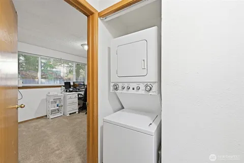 a view of washer and dryer with bathroom in the background
