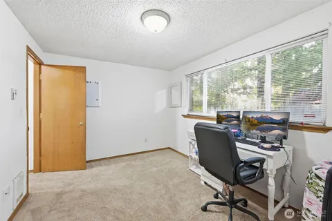 a view of a workspace with furniture and a window