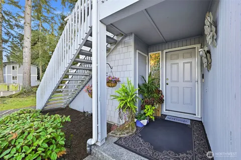 a view of a house with a potted plants and wooden fence