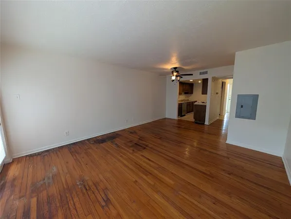 a view of empty room with wooden floor
