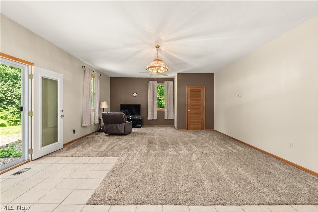 9990 Broadview Road Broadview Heights, OH 44147 - Photo 30 of 47 Unfurnished living room with light carpet and a chandelier