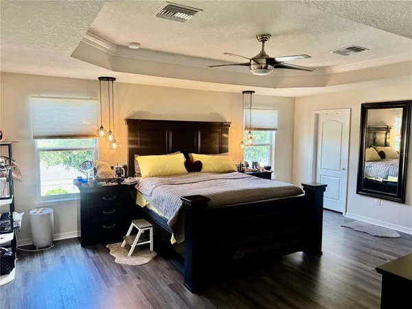 a bedroom with a bed and wooden floor