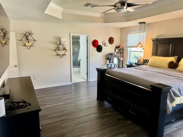 a bedroom with a bed and a dresser with wooden floor