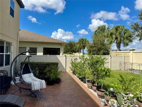 a view of a patio with couches table and chairs and potted plants