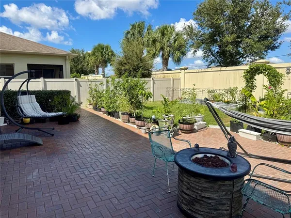 a backyard of a house with fountain table and chairs