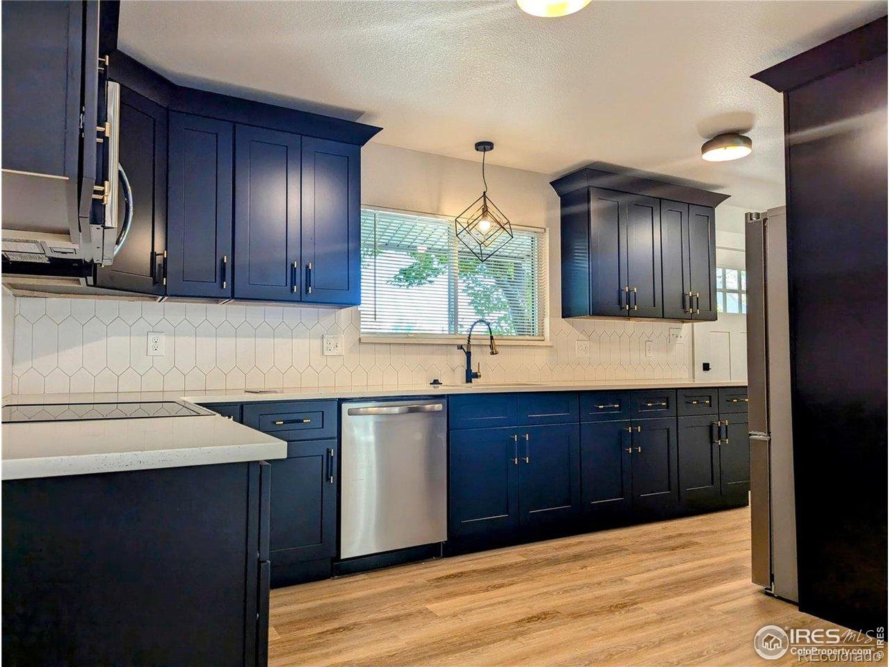 805 Gallup Road Fort Collins, CO 80521 - Photo 5 of 14 a kitchen with granite countertop wooden cabinets and a sink