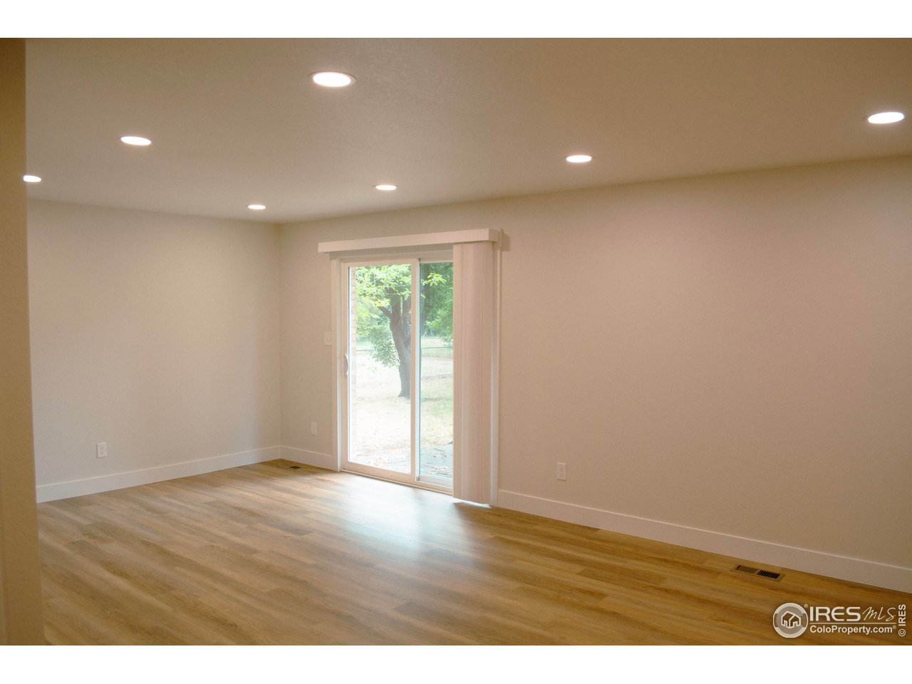 805 Gallup Road Fort Collins, CO 80521 - Photo 7 of 14 a view of an empty room with wooden floor and a window
