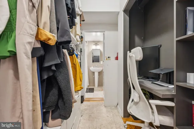 a view of walk in closet with clothes and shoes
