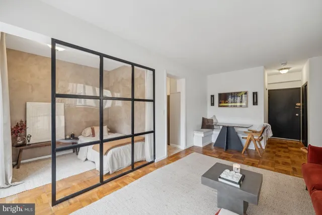 a living room with furniture a flat screen tv and a large window