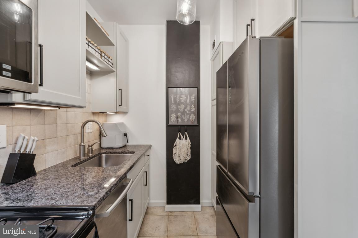1711 Massachusetts Avenue Northwest, Unit 413 Washington, DC 20036 - Photo 10 of 20 a kitchen with stainless steel appliances granite countertop a refrigerator and a sink
