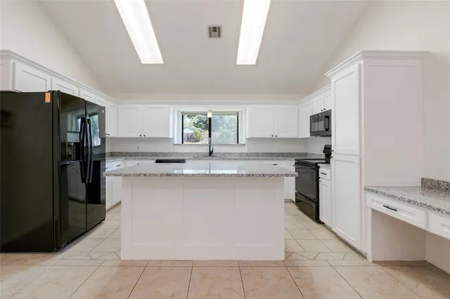 a kitchen with granite countertop a sink and a window