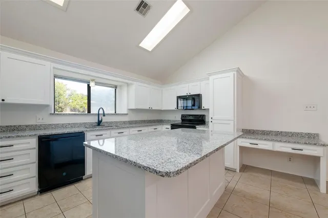 a kitchen with granite countertop a cabinets and appliances