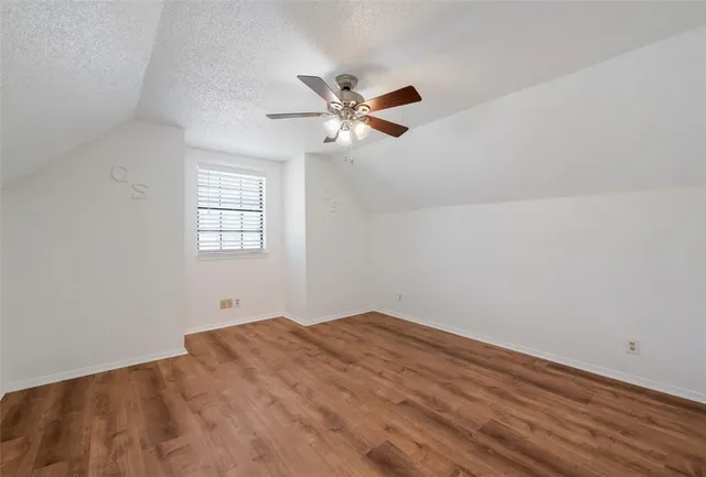 a view of a room with wooden floor and a ceiling fan