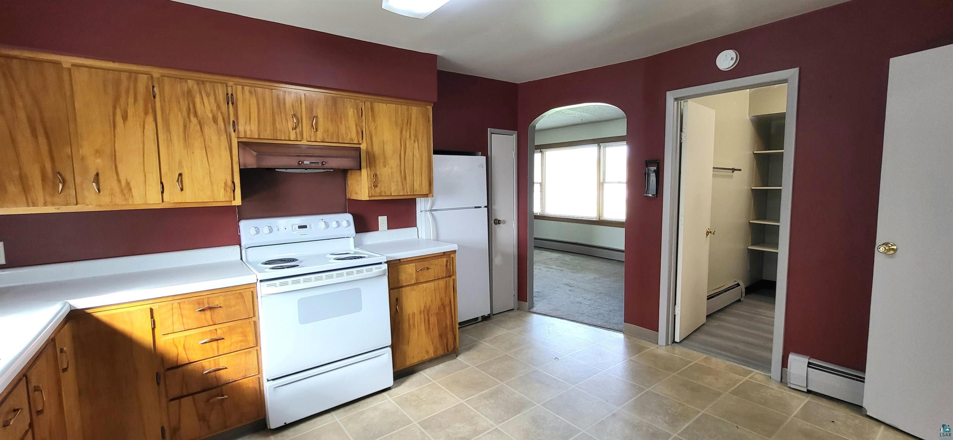 56 East 2nd Street Superior, WI 54880 - Photo 5 of 18 Kitchen featuring light wood-finish cabinetry, white countertops, and white appliances including an electric range and refrigerator