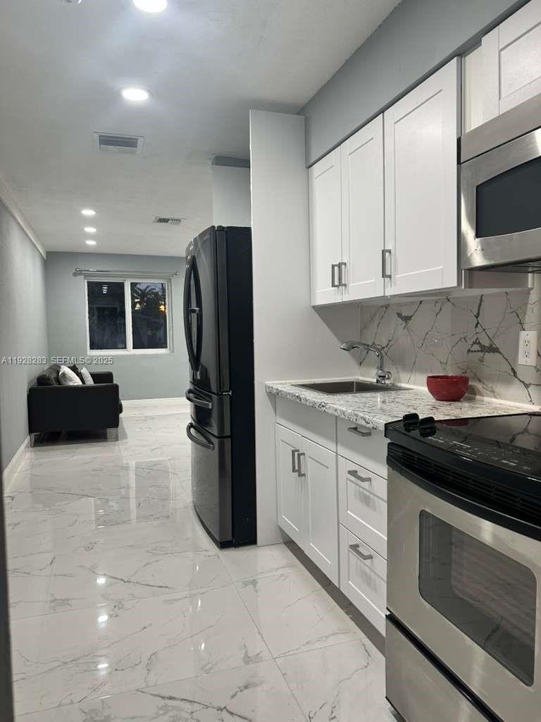 4960 Southwest 28th Terrace Dania Beach, FL 33312 - Photo 5 of 10 a kitchen with a sink a stove and refrigerator