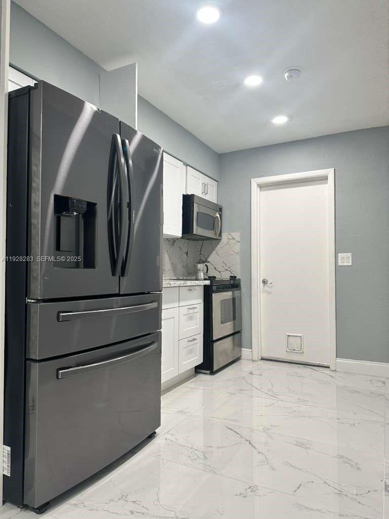 4960 Southwest 28th Terrace Dania Beach, FL 33312 - Photo 7 of 10 a kitchen with stainless steel appliances a refrigerator stove and microwave