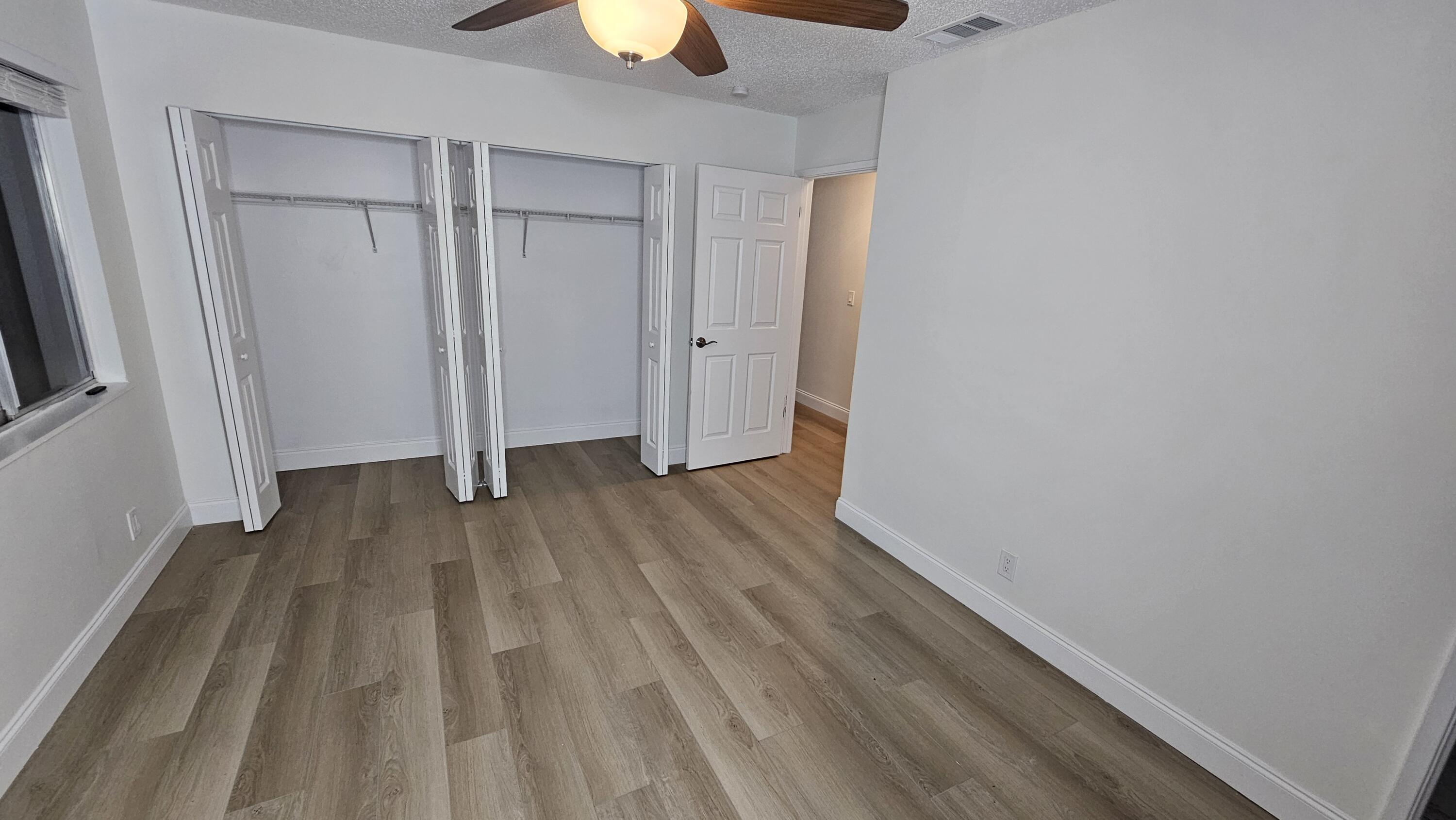 18974 Cloud Lake Circle Boca Raton, FL 33496 - Photo 12 of 29 a view of a room with wooden floor and a ceiling fan