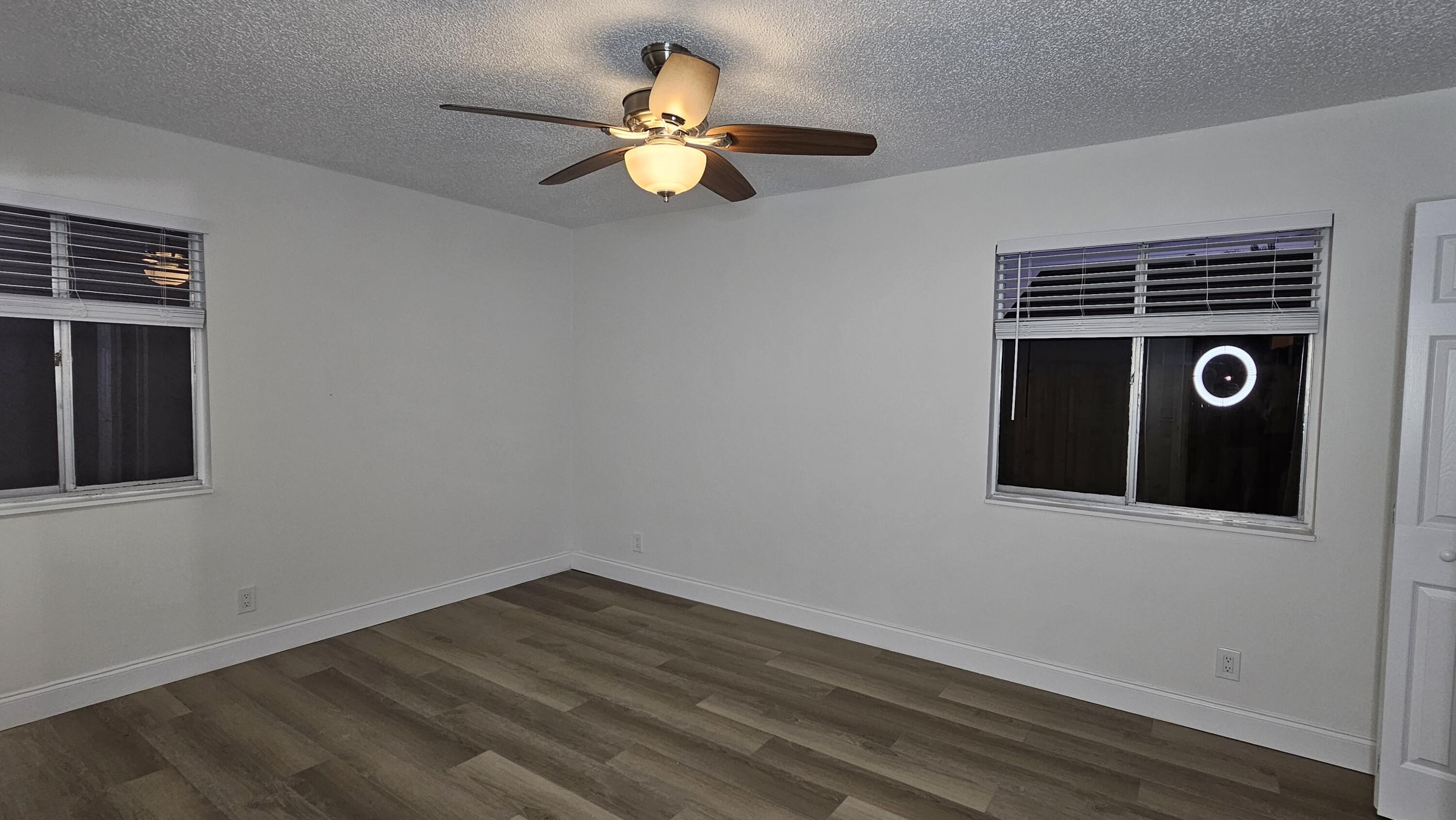 18974 Cloud Lake Circle Boca Raton, FL 33496 - Photo 13 of 29 a view of a livingroom with wooden floor and a ceiling fan