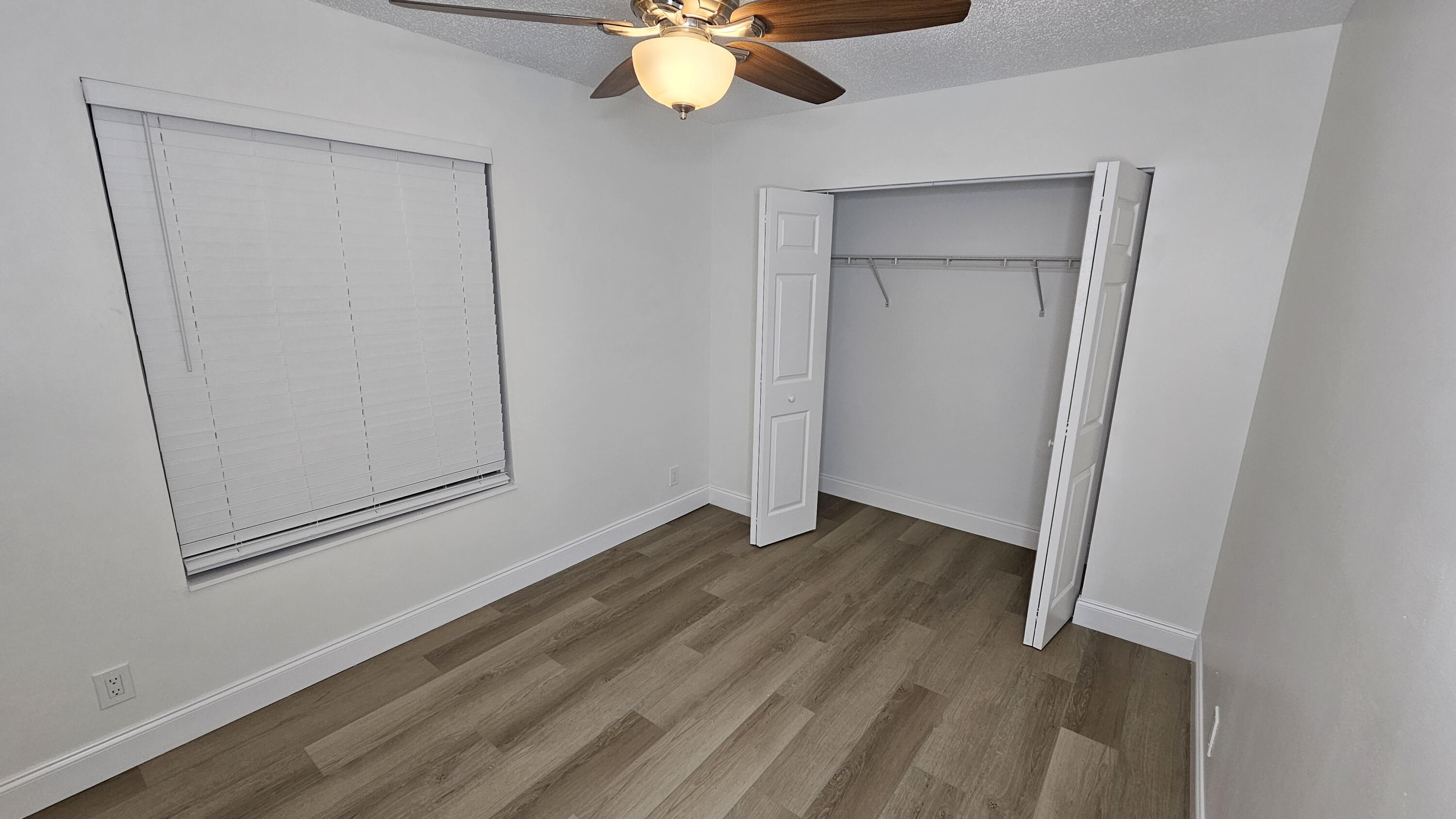 18974 Cloud Lake Circle Boca Raton, FL 33496 - Photo 18 of 29 an empty room with wooden floor fan and windows