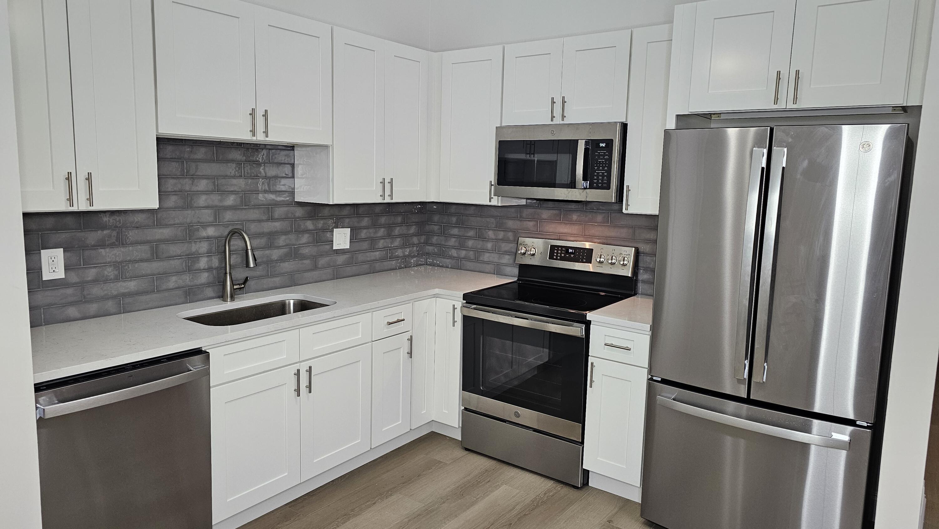 18974 Cloud Lake Circle Boca Raton, FL 33496 - Photo 3 of 29 a kitchen with white cabinets sink and stainless steel appliances