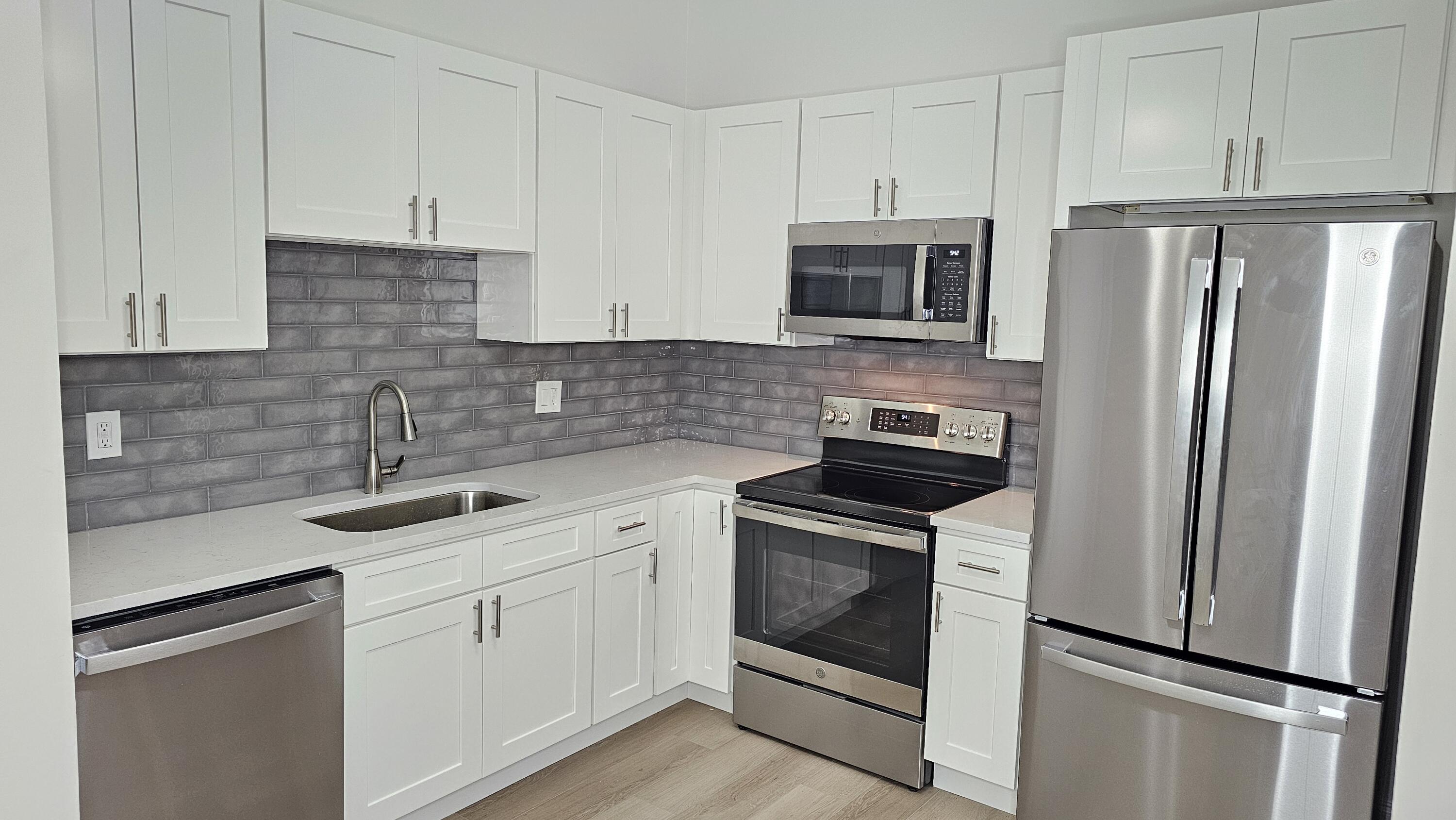 18974 Cloud Lake Circle Boca Raton, FL 33496 - Photo 4 of 29 a kitchen with stainless steel appliances granite countertop white cabinets a refrigerator stove a sink and dishwasher