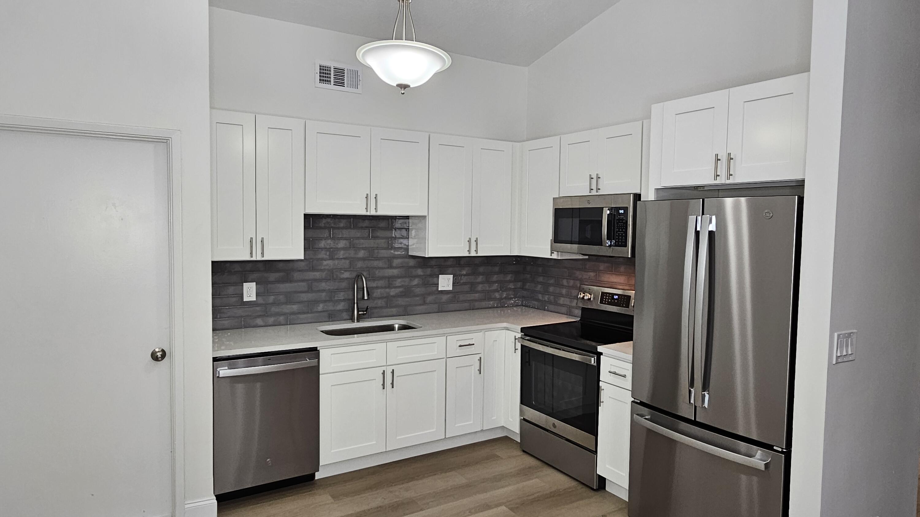 18974 Cloud Lake Circle Boca Raton, FL 33496 - Photo 5 of 29 a kitchen with stainless steel appliances granite countertop a refrigerator and a stove top oven