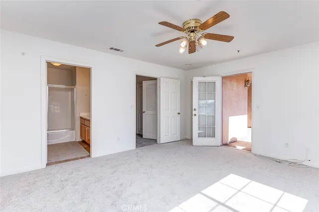 a view of an empty room with a ceiling fan