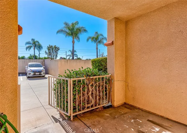 a view of a porch with a floor to ceiling window and potted plants