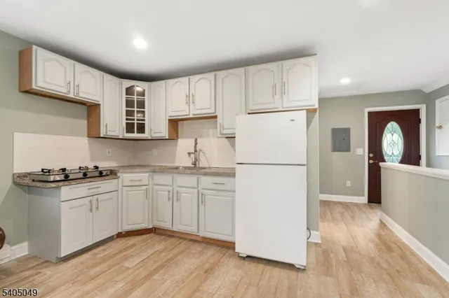 an empty room with wooden floor chandelier fan and windows