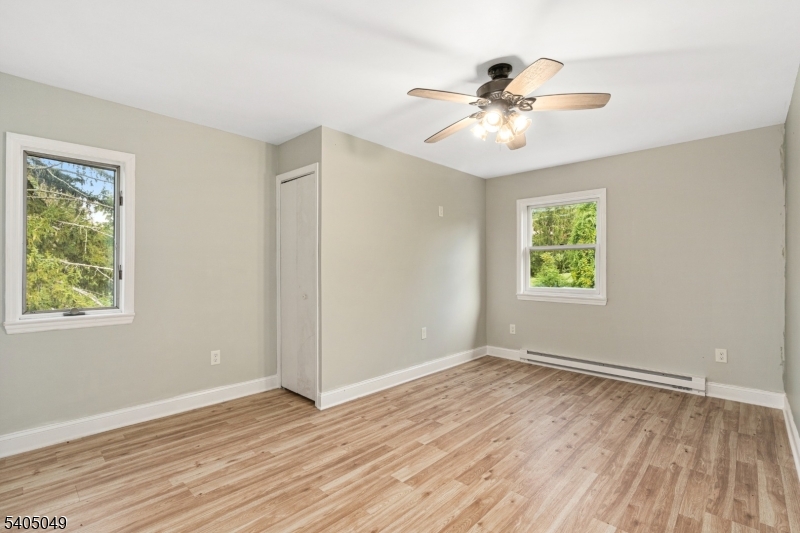 148 Highway 94 Vernon, NJ 07462 - Photo 23 of 33 an empty room with wooden floor chandelier fan and windows