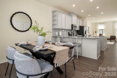 a kitchen with a table chairs a stove a microwave a dining table and chairs