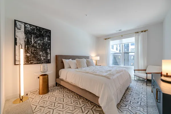 a bedroom with a bed and a lamp on table