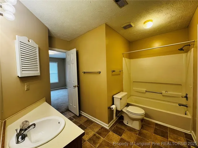 a view of empty room with floor to ceiling window and ceiling fan